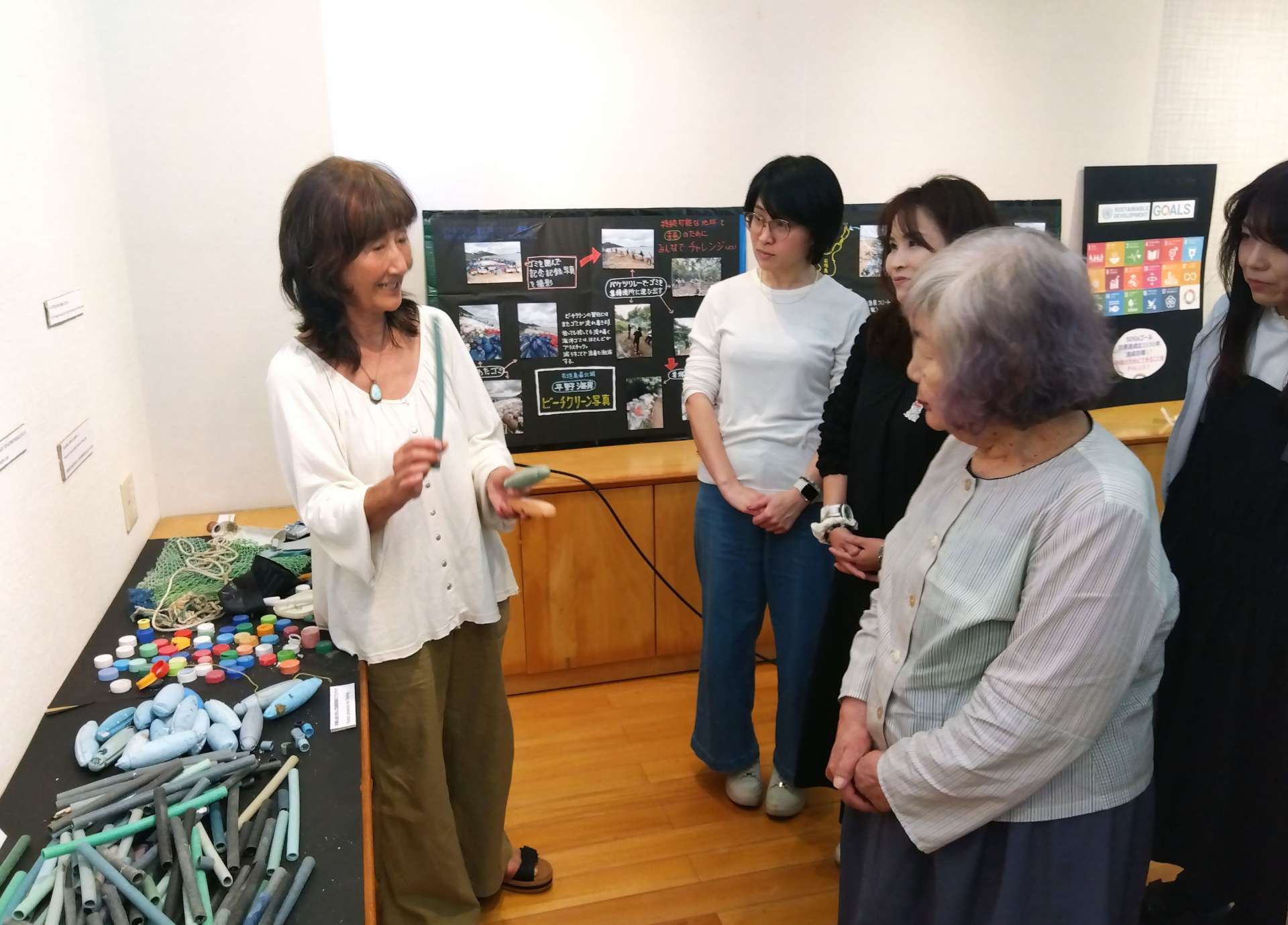 漂着プラスチックごみの深刻さを説明する中川久美子さん（左端）＝５月３１日、都城市鷹尾４丁目