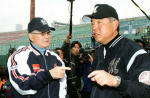 県立鴨池球場（現・平和リース球場）で、報道陣に囲まれる日本代表監督の長嶋茂雄さん（左）＝２００３年２月２６日、鹿児島市