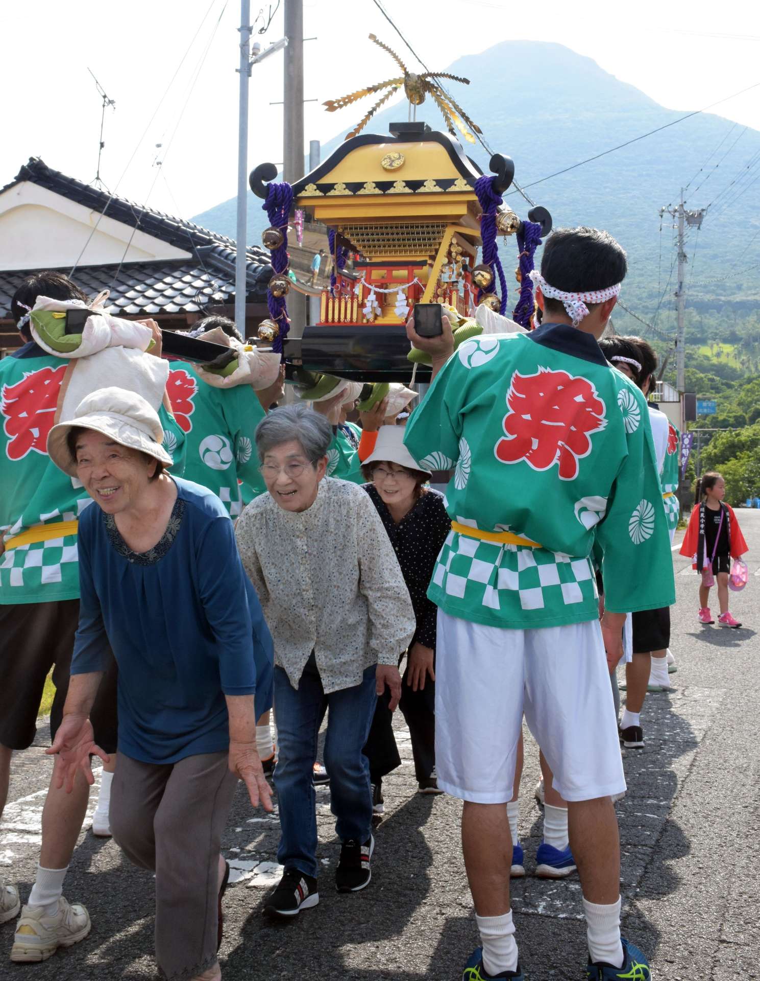 無病息災を願い、みこしの下をくぐる住民＝５月３１日、指宿市開聞川尻