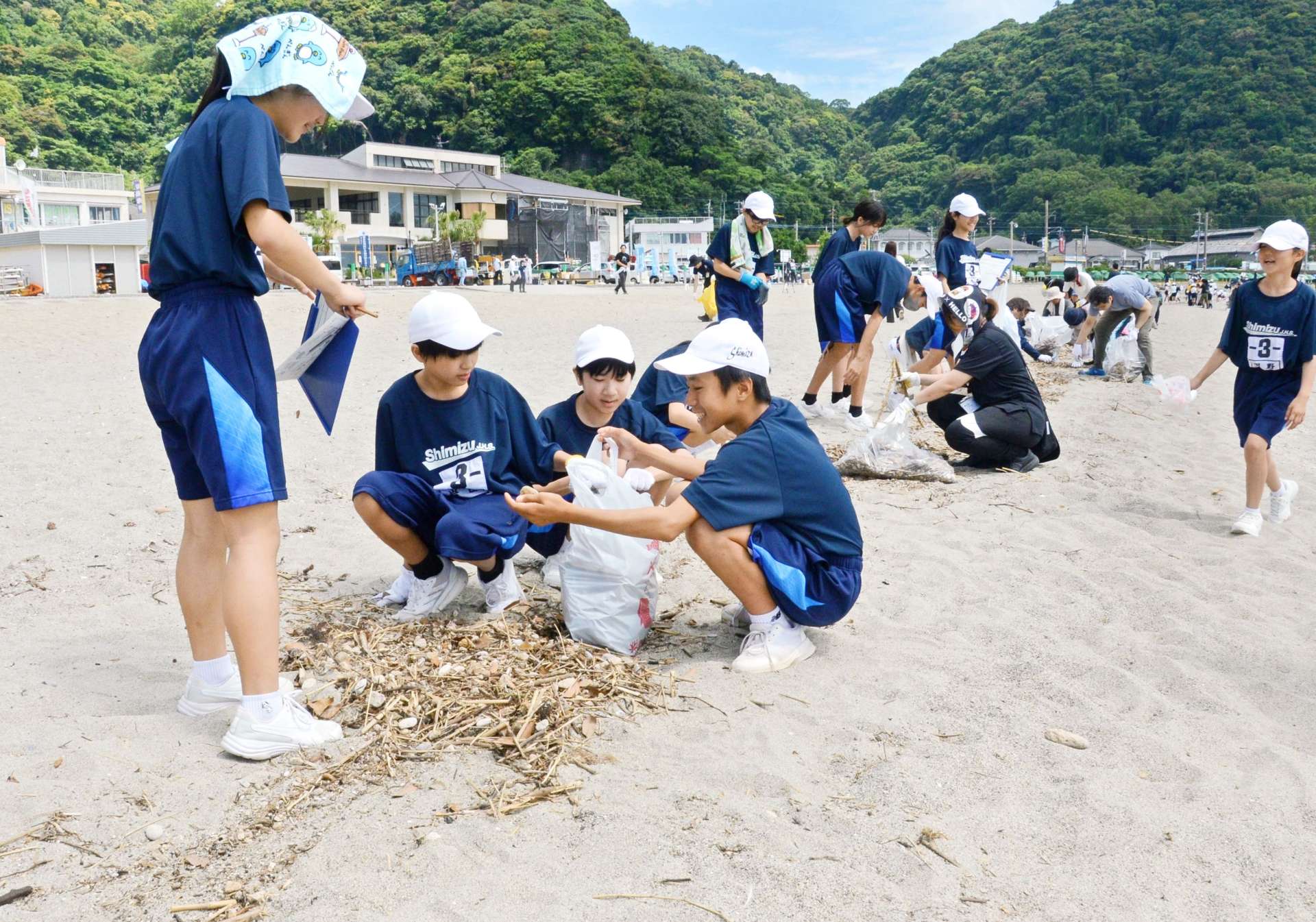 海岸のごみを拾う中学生＝６日、鹿児島市の磯海水浴場