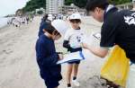海岸のごみを拾う小学生＝６日、鹿児島市の磯海水浴場