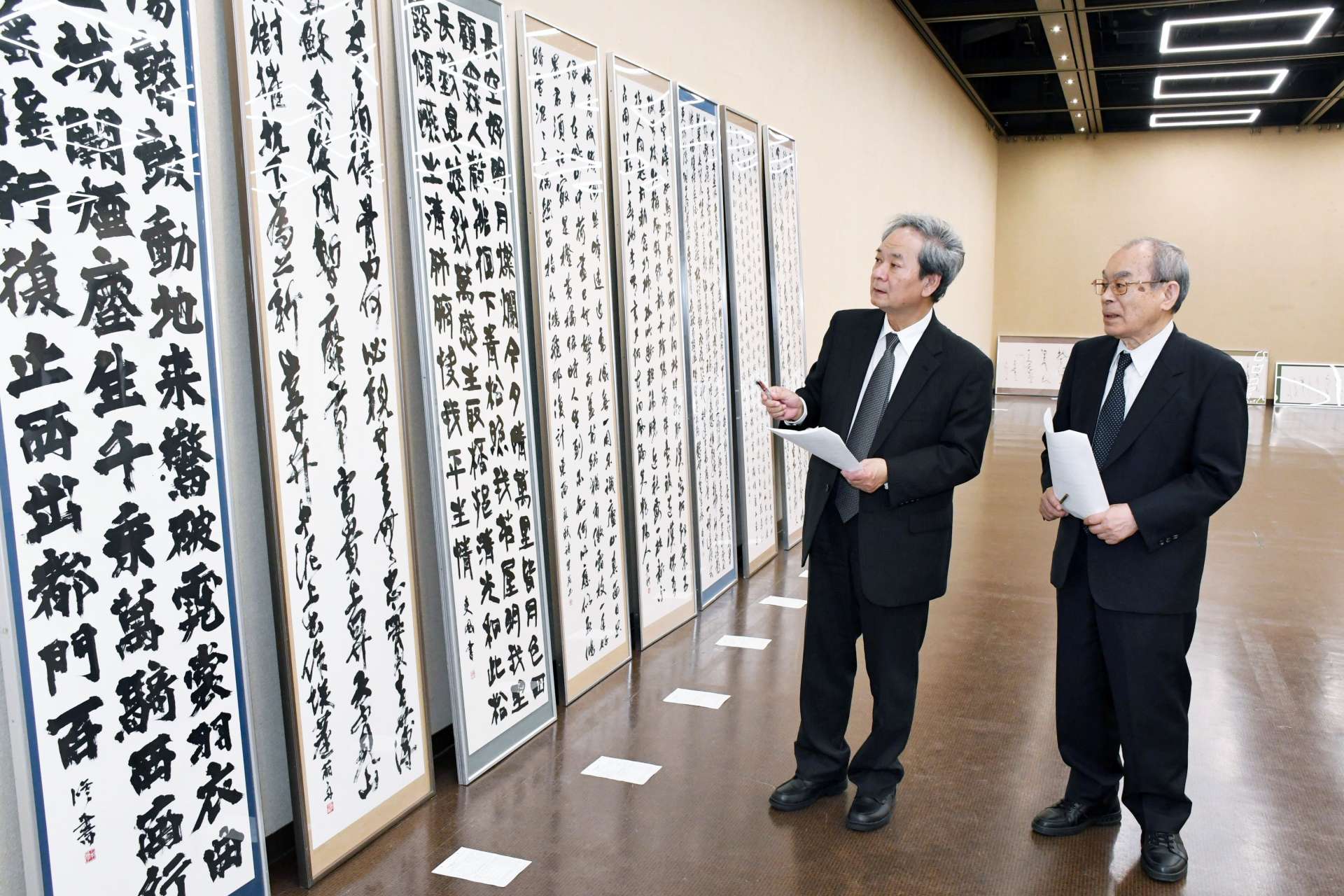 応募作品を審査する中村伸夫氏（左）と松清秀仙氏＝４日、鹿児島市の黎明館