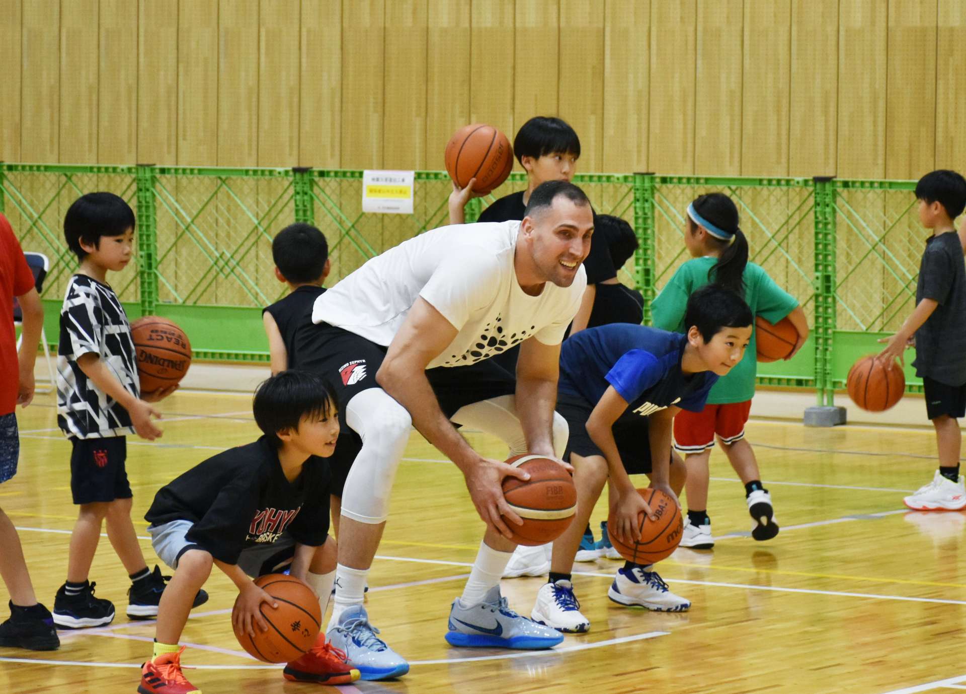 子どもたちにバスケットボールを教えるパブロ・アギラール選手（中央）＝鹿屋市白水町の鹿屋体育大学