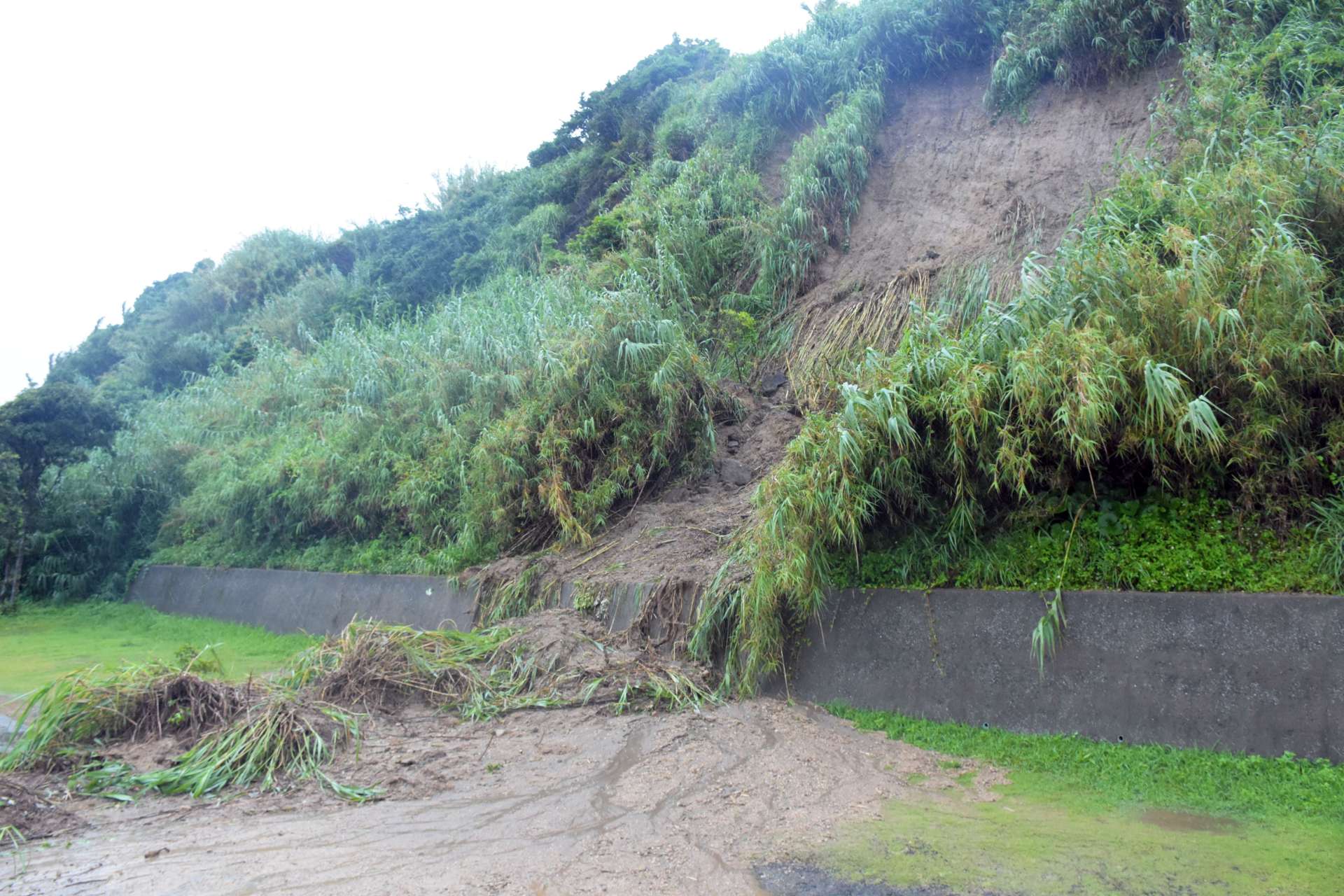 大雨の影響で斜面から流れ出した土砂＝９日、指宿市山川福元