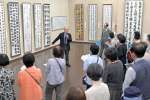 審査員による作品解説に耳を傾ける来場者＝１０日、鹿児島市の黎明館