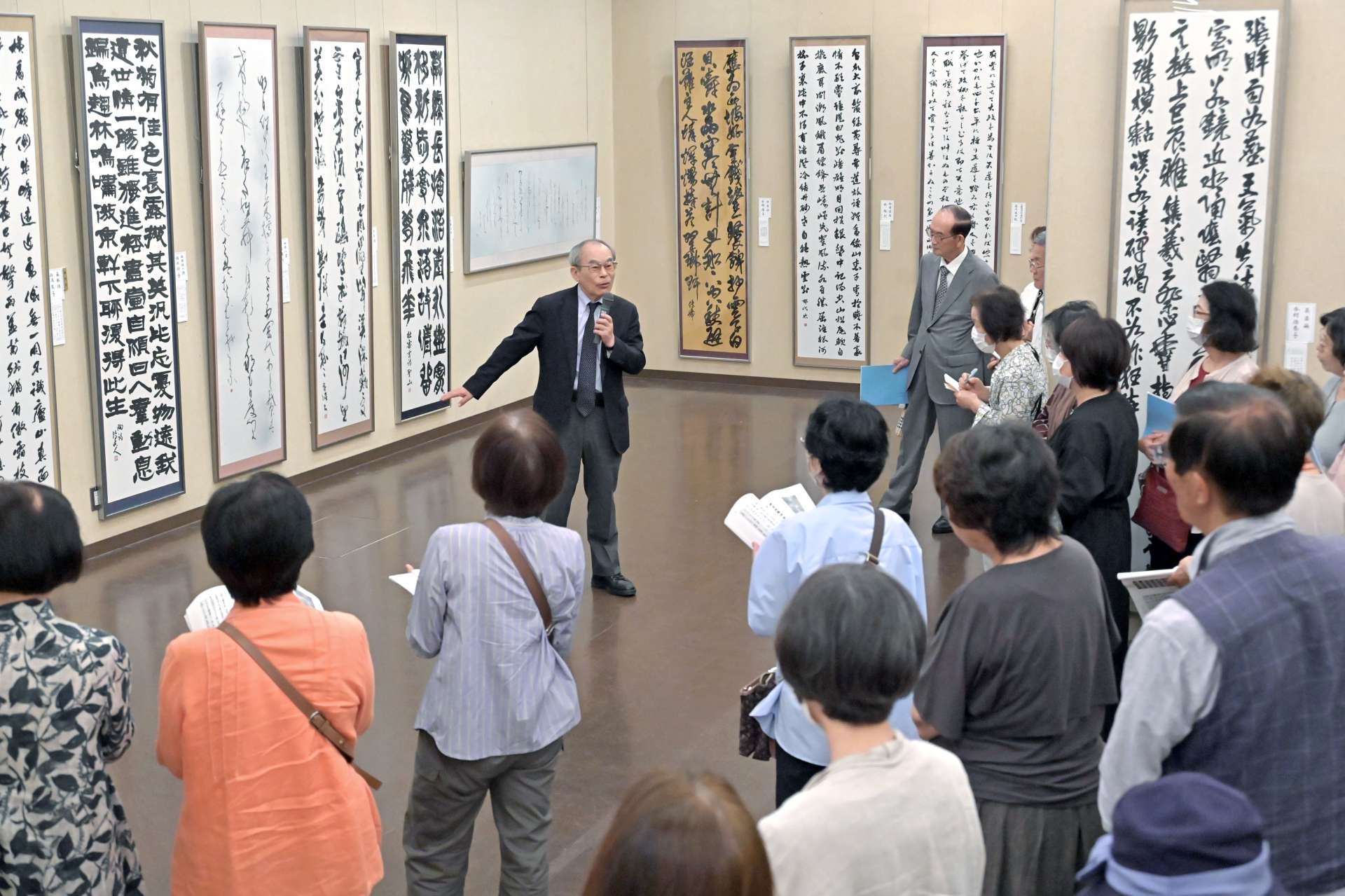 審査員による作品解説に耳を傾ける来場者＝１０日、鹿児島市の黎明館