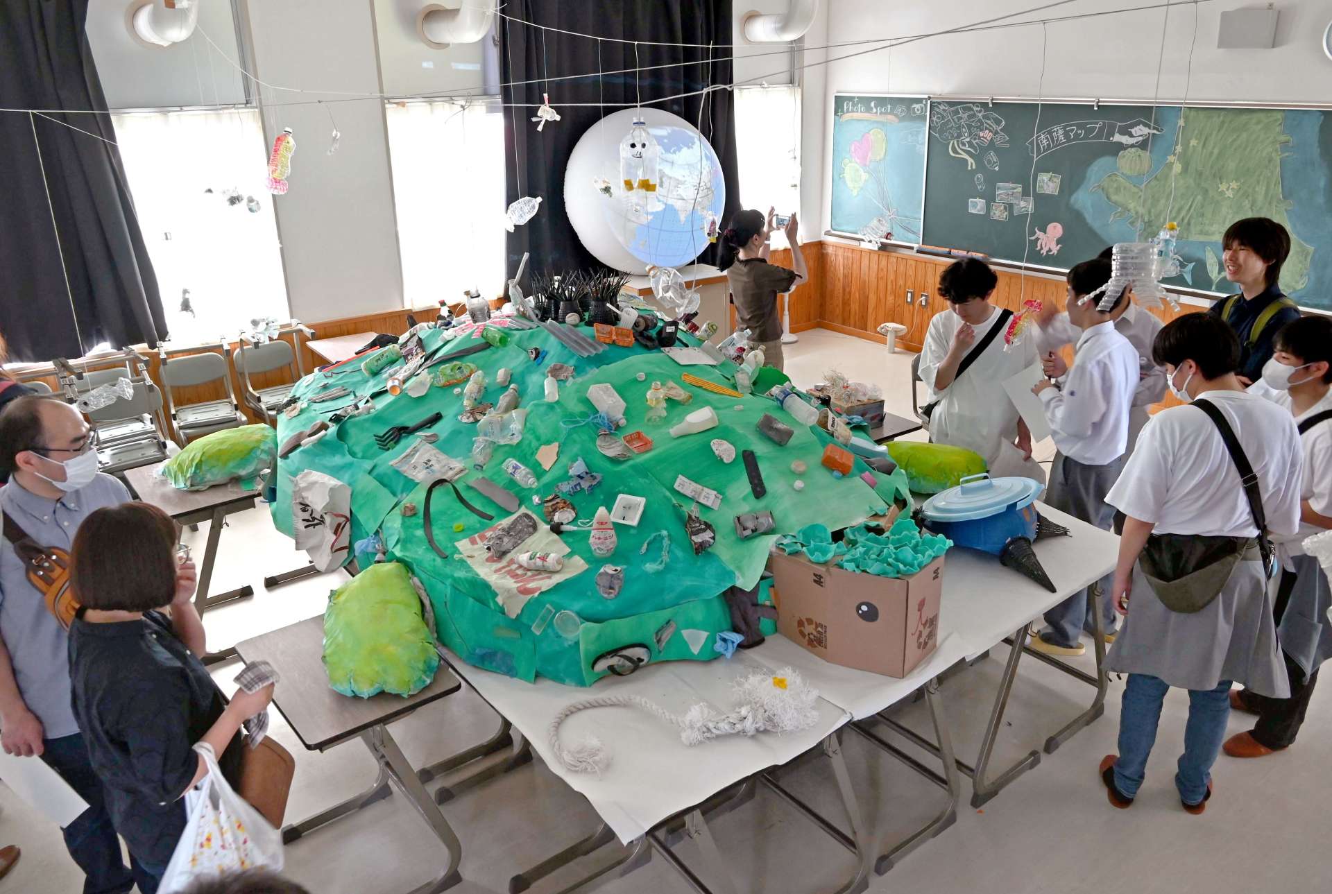 海洋ごみで飾ったウミガメのオブジェを見学する来場者＝７日、南さつま市の加世田高校