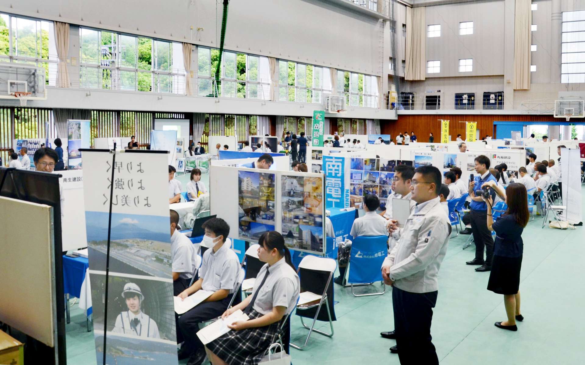 担当者から説明を受ける高校生＝１０日、鹿児島市五ケ別府町の鹿児島実業高校