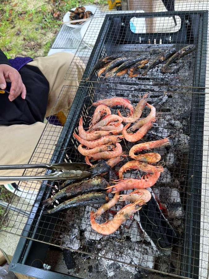 ４カ所目のチェックポイントで用意されていたタカエビとイワシの炭火焼き＝５月１１日、薩摩川内市下甑の長浜緑地公園