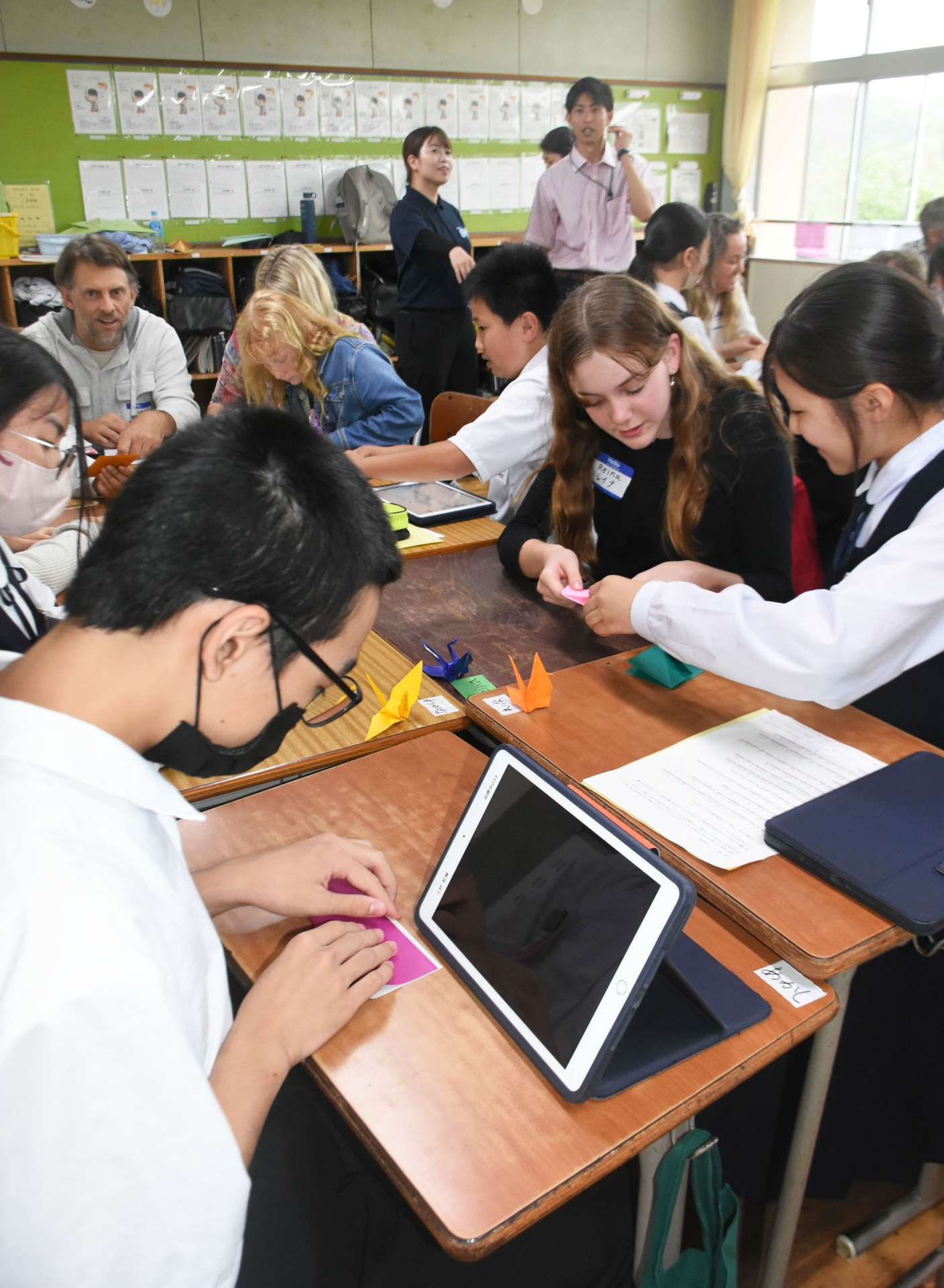 一緒に折り鶴を作り交流する参加者＝２日、鹿屋市の高隈中学校