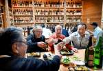 全国の焼酎が並ぶ会場で乾杯する参加者＝南さつま市の宮原ふれあい館