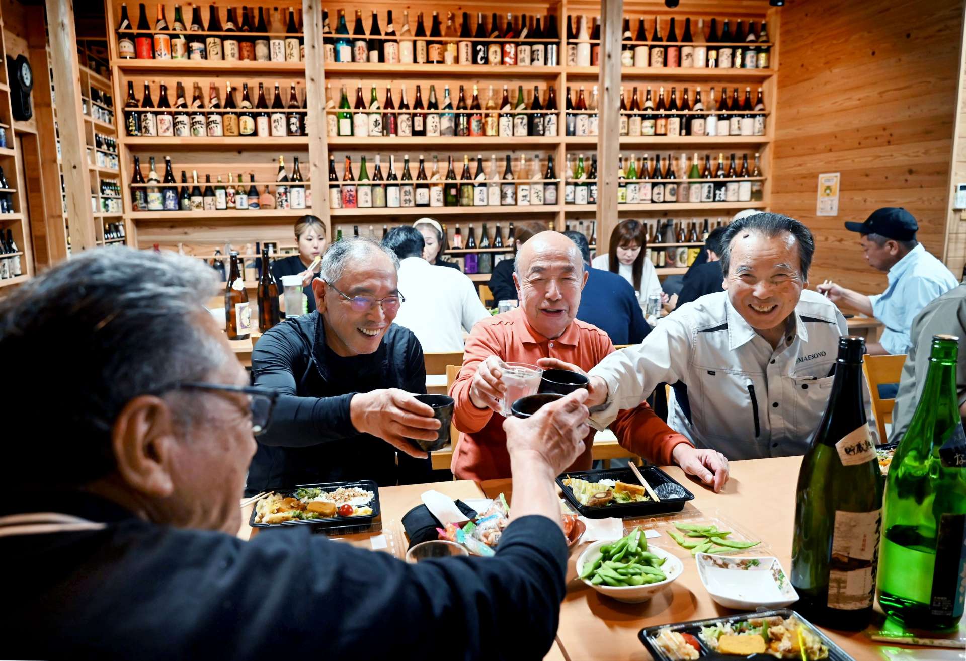 全国の焼酎が並ぶ会場で乾杯する参加者＝南さつま市の宮原ふれあい館