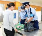 クルーズ船下船時の手荷物検査の様子を再現する税関職員＝５月３０日、鹿児島市のマリンポートかごしま