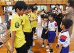手作りのメダルを渡した野田小学校の児童（右側）＝９日、出水市の同校