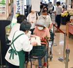 列をつくり備蓄米を受け取る客＝１４日午前９時、南さつま市加世田本町のピコ