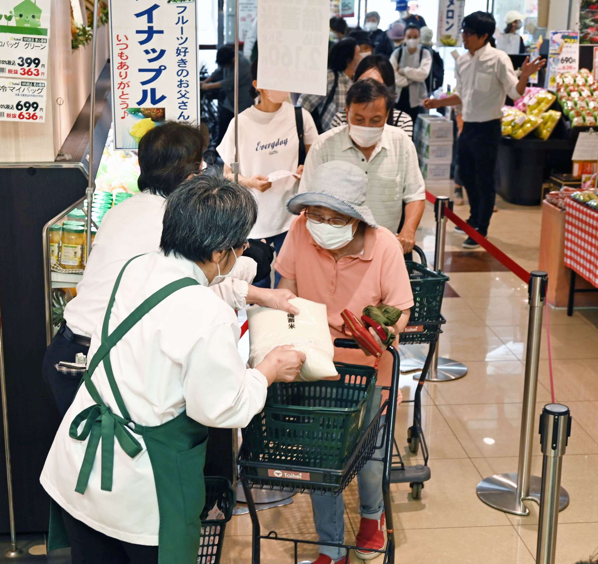 列をつくり備蓄米を受け取る客＝１４日午前９時、南さつま市加世田本町のピコ