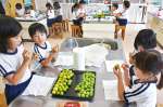 梅に穴を開けて、ジュース作りに挑戦する児童＝６日、錦江町の田代小学校