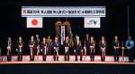 隼人道路の４車線化工事完成を祝いテープカットとくす玉を割る来賓ら＝１５日、霧島市隼人町内山田の隼人農村環境改善センター