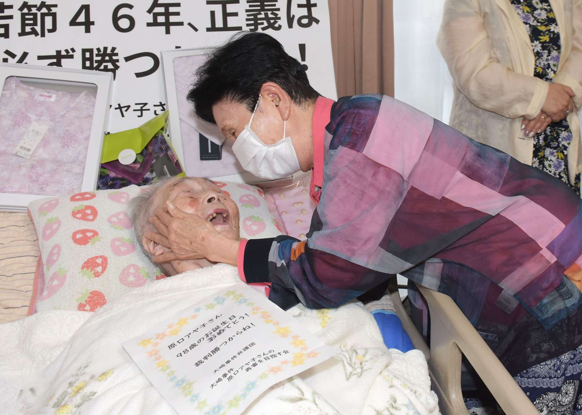 原口アヤ子さんの頬に手を当て「次はアヤ子さんの番」と励ます袴田ひで子さん＝１５日、鹿児島県内