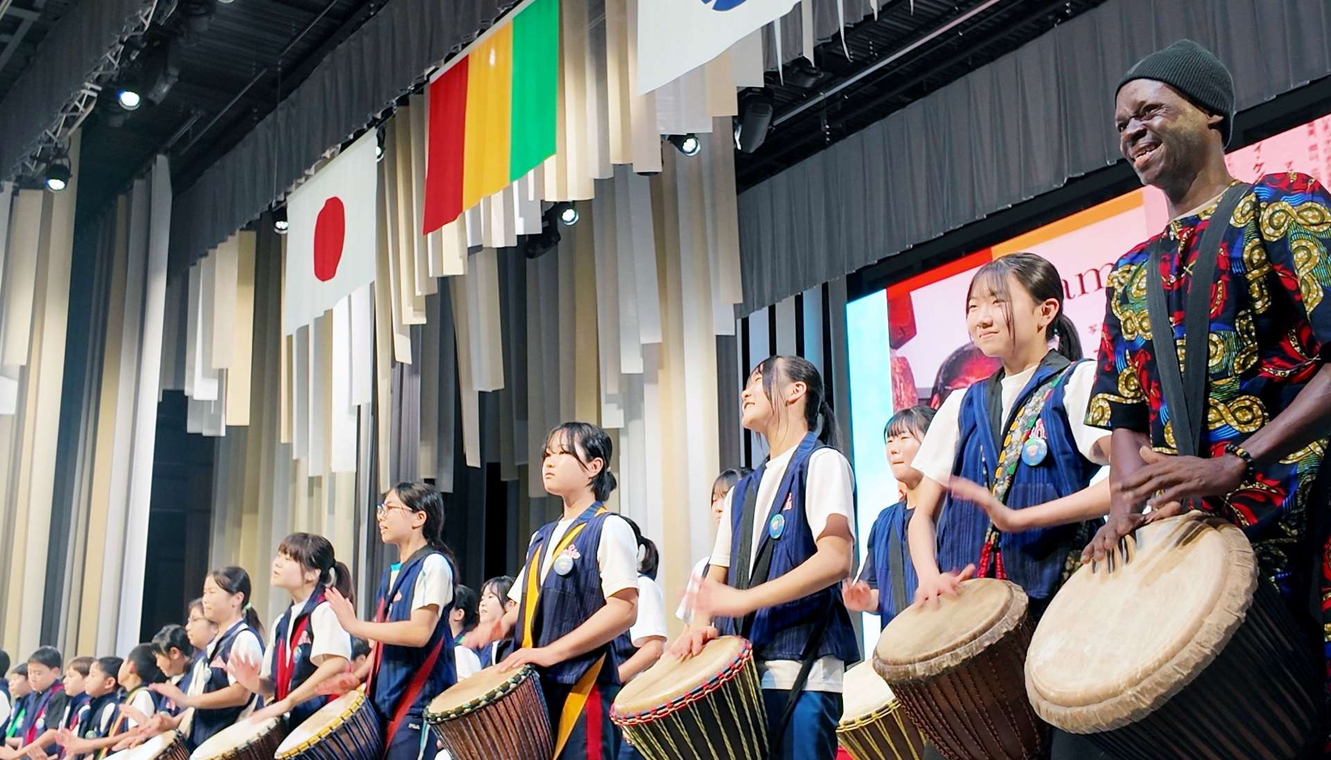 ギニアナショナルデーでジャンベを演奏する三島村４義務教育学校の子どもたち＝１０日、大阪市の大阪・関西万博会場（三島硫黄島学園提供）