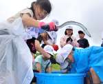 ウナギを放流する亀山小学校の児童ら＝１０日、薩摩川内市の川内川
