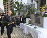 「人間之碑」に献花する遺族会員ら＝１７日、鹿児島市易居町
