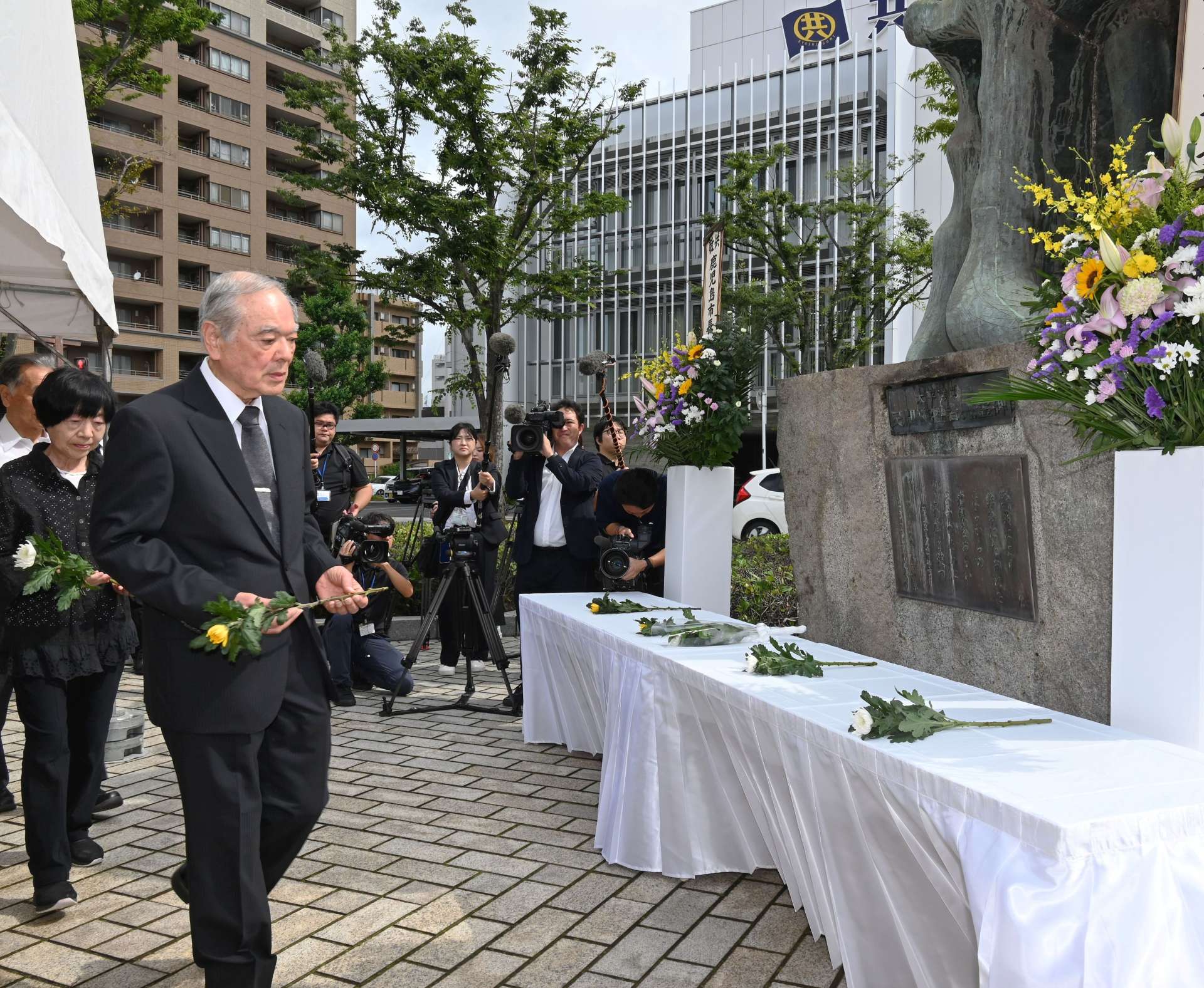 「人間之碑」に献花する遺族会員ら＝１７日、鹿児島市易居町