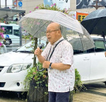 雨の中、集まった鹿児島県民らに核兵器廃絶を訴える田中重光さん＝ＪＲ鹿児島中央駅東口
