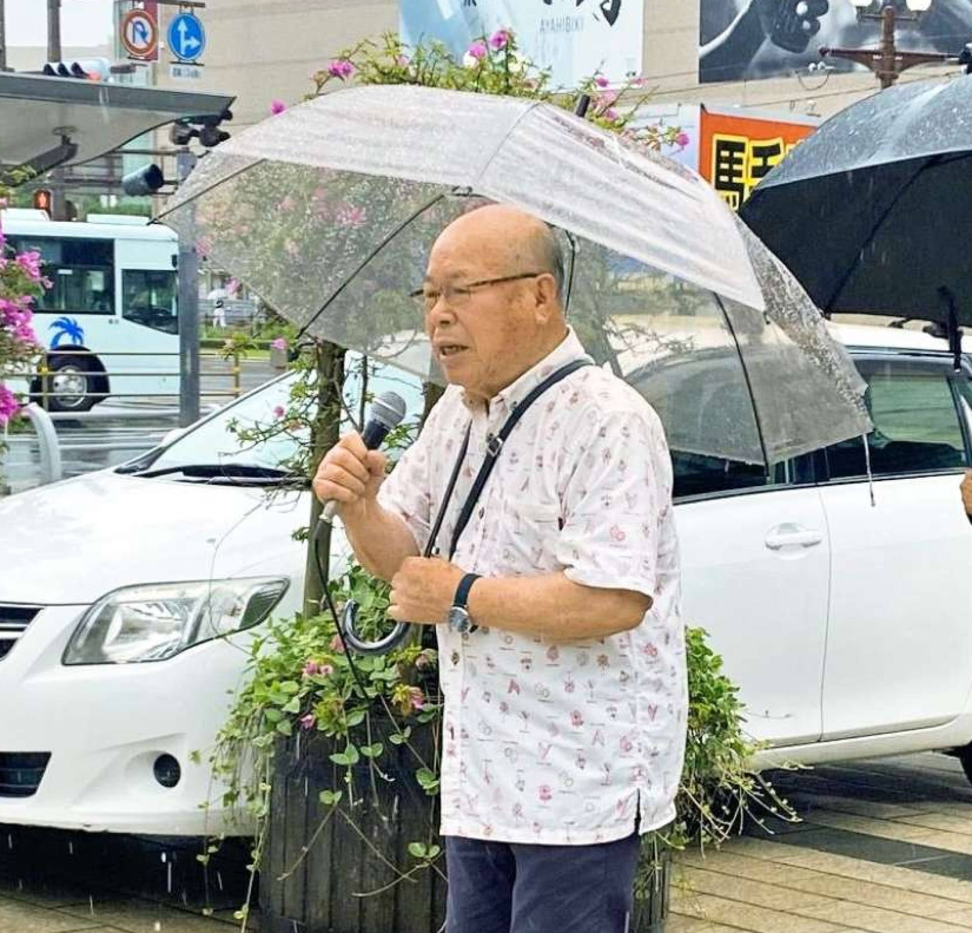 雨の中、集まった鹿児島県民らに核兵器廃絶を訴える田中重光さん＝ＪＲ鹿児島中央駅東口