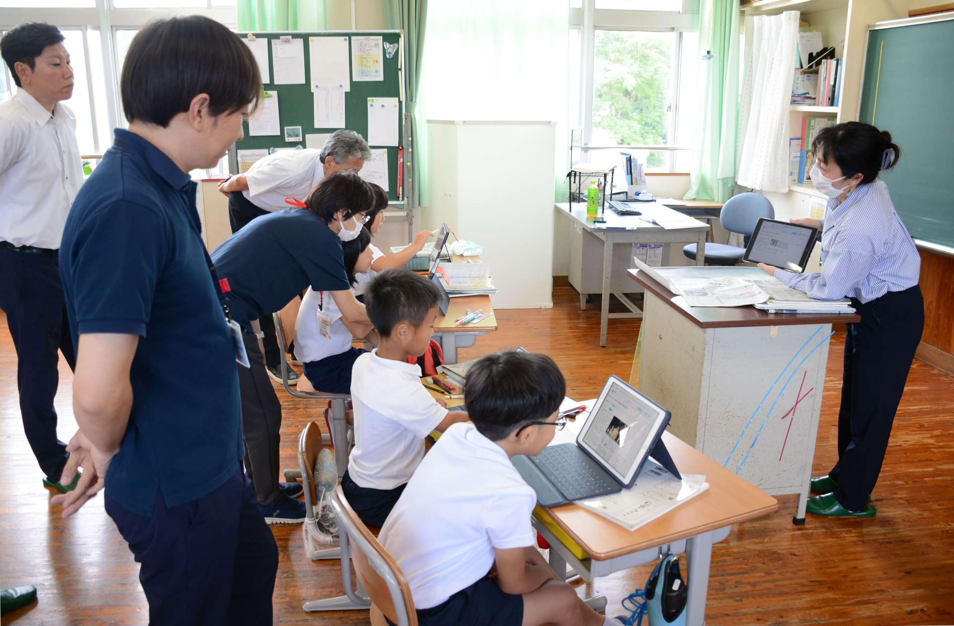 タブレット端末で新聞記事を読み込む児童＝１８日、南九州市知覧の中福良小学校