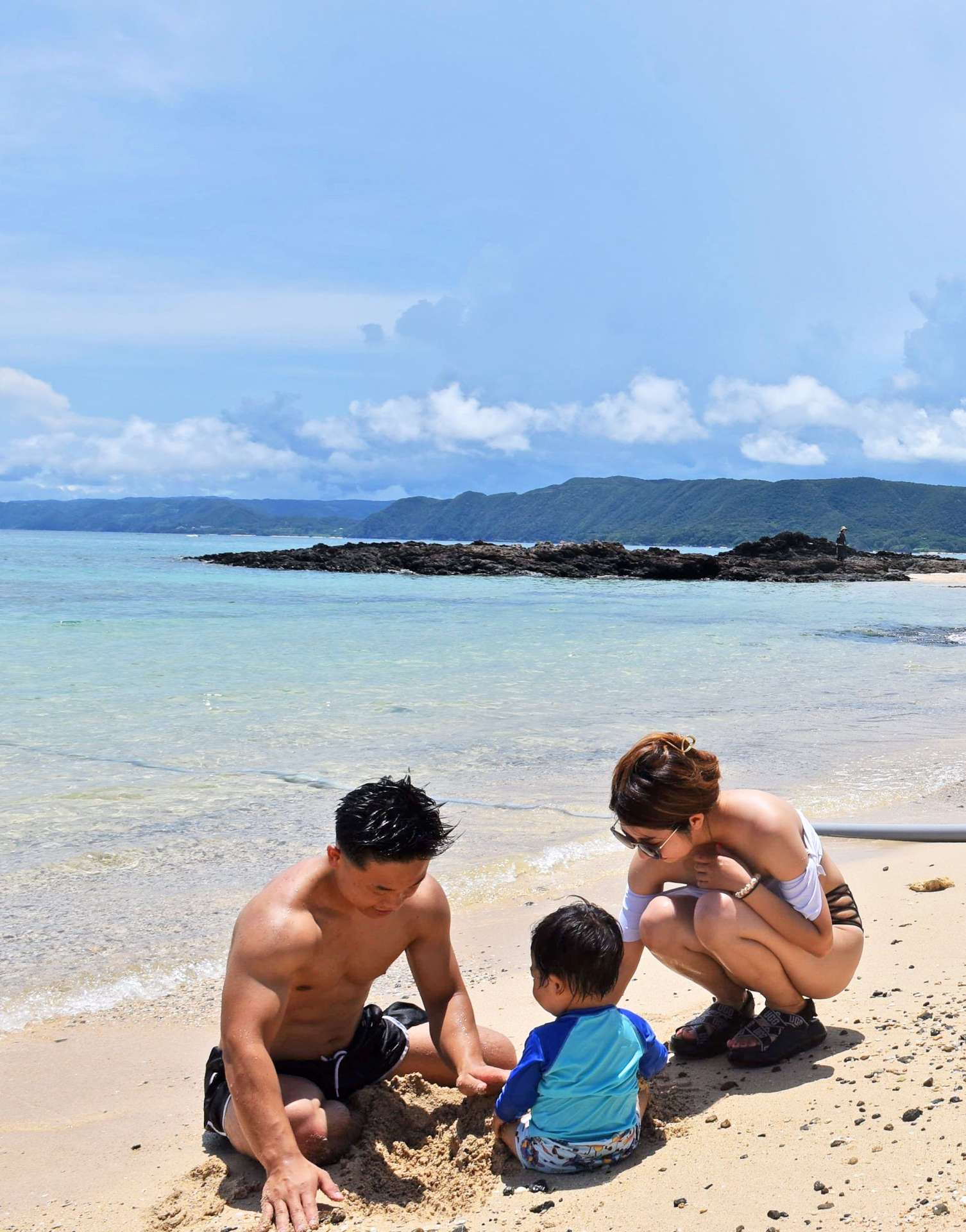 青空の下、海水浴を楽しむ家族連れ＝１９日、奄美市笠利の用安海岸