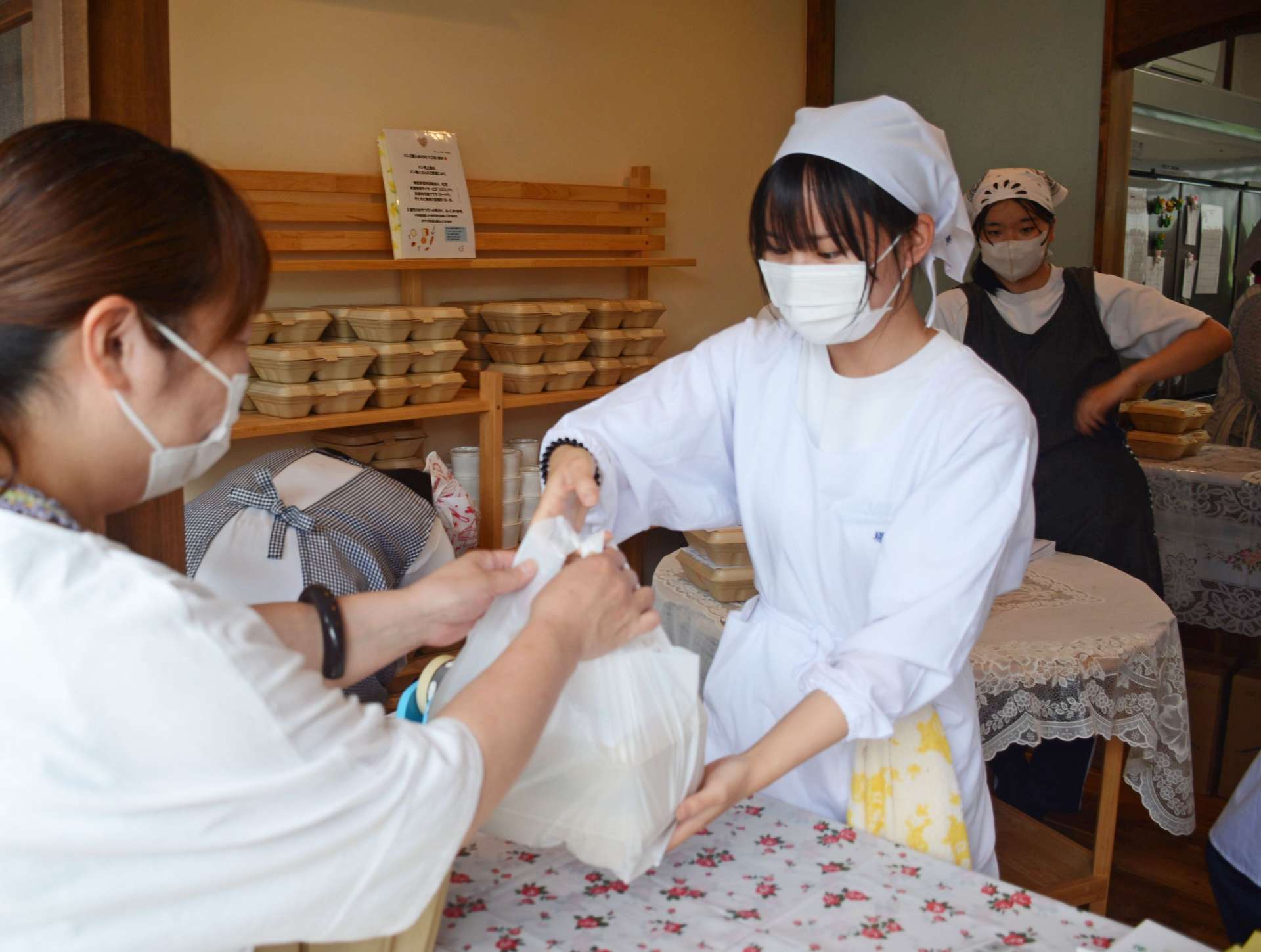 弁当を利用者に手渡す薩南工業高校の生徒＝１４日、南九州市知覧町郡