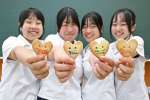創立２０周年を記念したクッキーをアピールする生徒たち＝西之表市の種子島高校