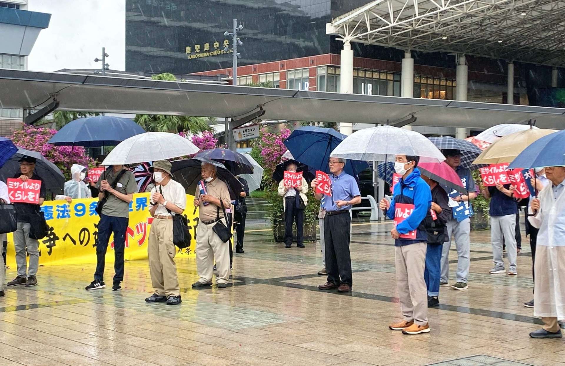 プラカードを手に、軍拡反対の意思を示す市民ら＝ＪＲ鹿児島中央駅東口