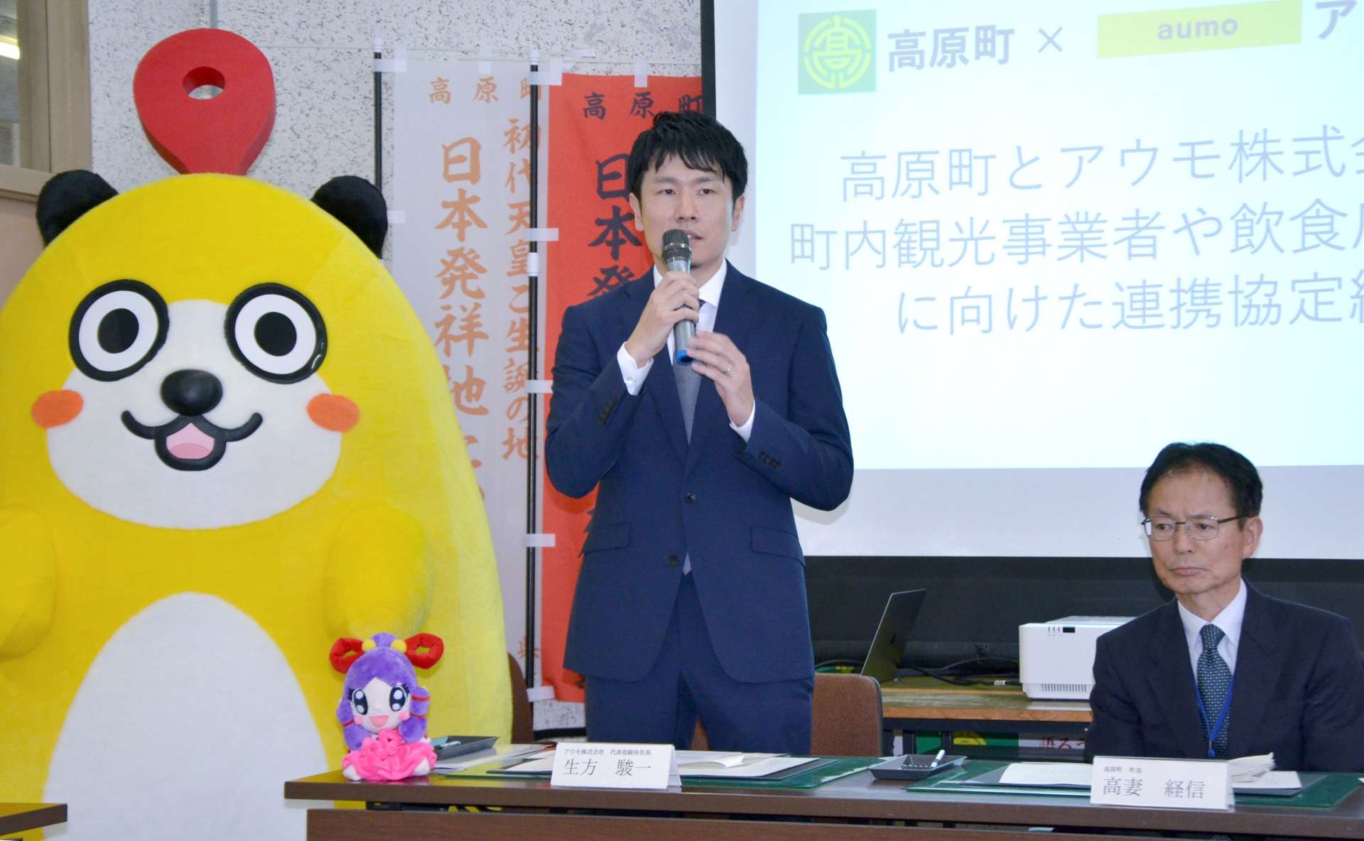 協定締結式で抱負を述べるアウモの生方駿一社長（左）＝２０日、宮崎県高原町役場