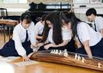 箏曲の演奏に挑戦するマイアミ市の高校生（中央）＝１８日、鹿児島市玉里町の鹿児島女子高校