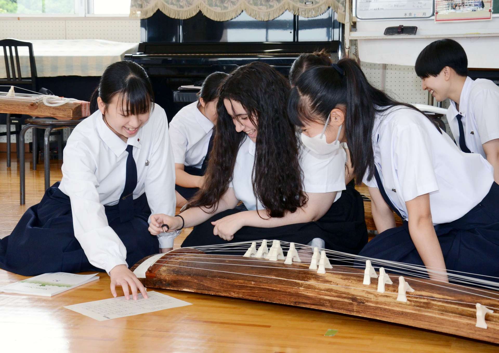 箏曲の演奏に挑戦するマイアミ市の高校生（中央）＝１８日、鹿児島市玉里町の鹿児島女子高校