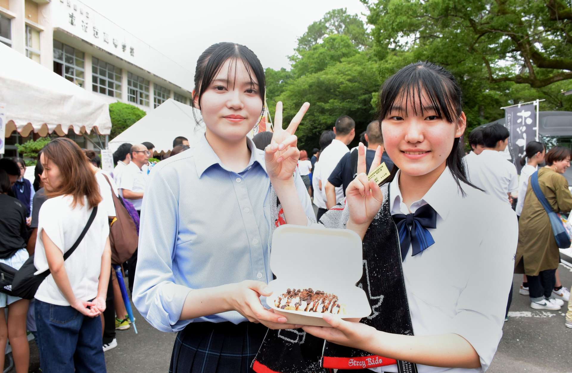 志布志高校文化祭・マルシェでクロッフルを手に笑顔を見せる高校生＝志布志市の同校