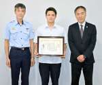 薩摩川内市中央消防署の浜田浩署長（左）から感謝状を受けた藤田幸輝さん（中央）＝鹿児島市の鹿児島高校