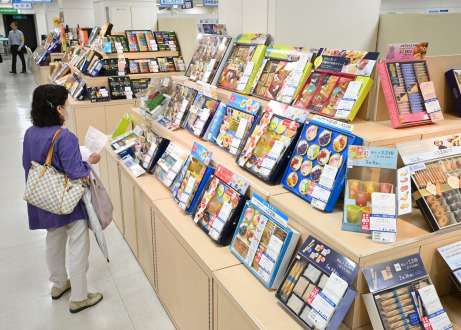 お中元の特設コーナーで、商品を吟味する買い物客＝２４日、鹿児島市の山形屋