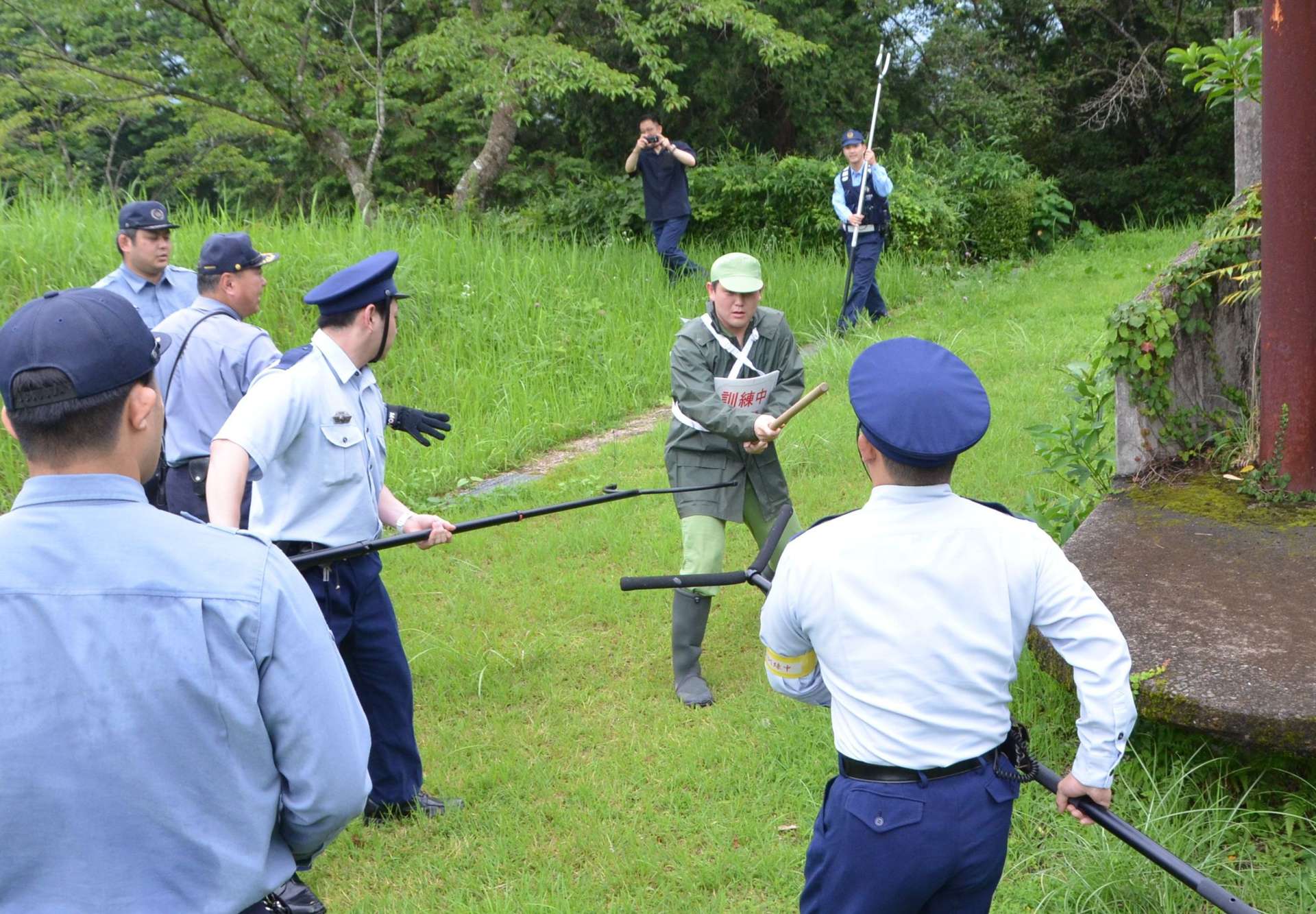 〈関連〉抵抗する受刑者役を取り囲む刑務所職員＝２４日、湧水町中津川