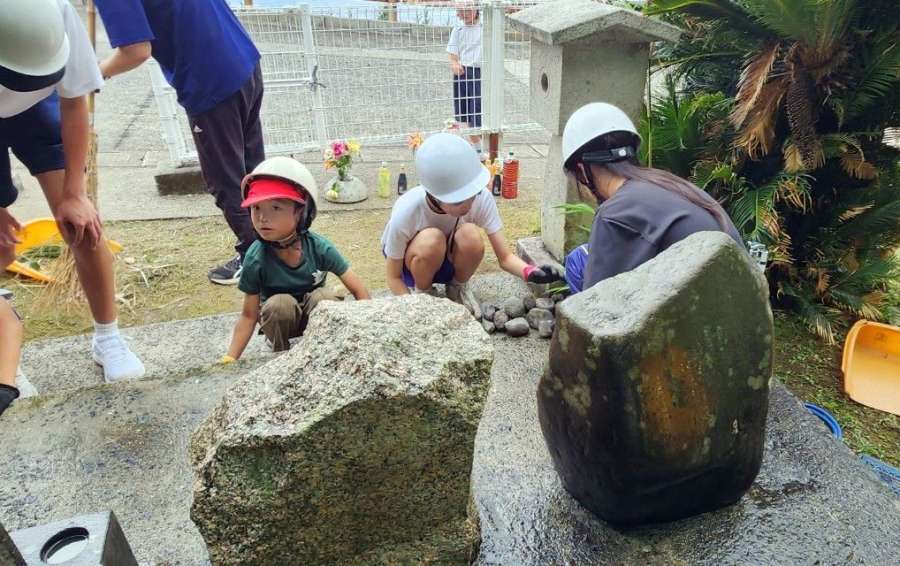 ヘルメットを着けて野外活動に取り組む子どもたち＝２４日午後２時半ごろ、十島村悪石島の悪石島学園（同学園提供）