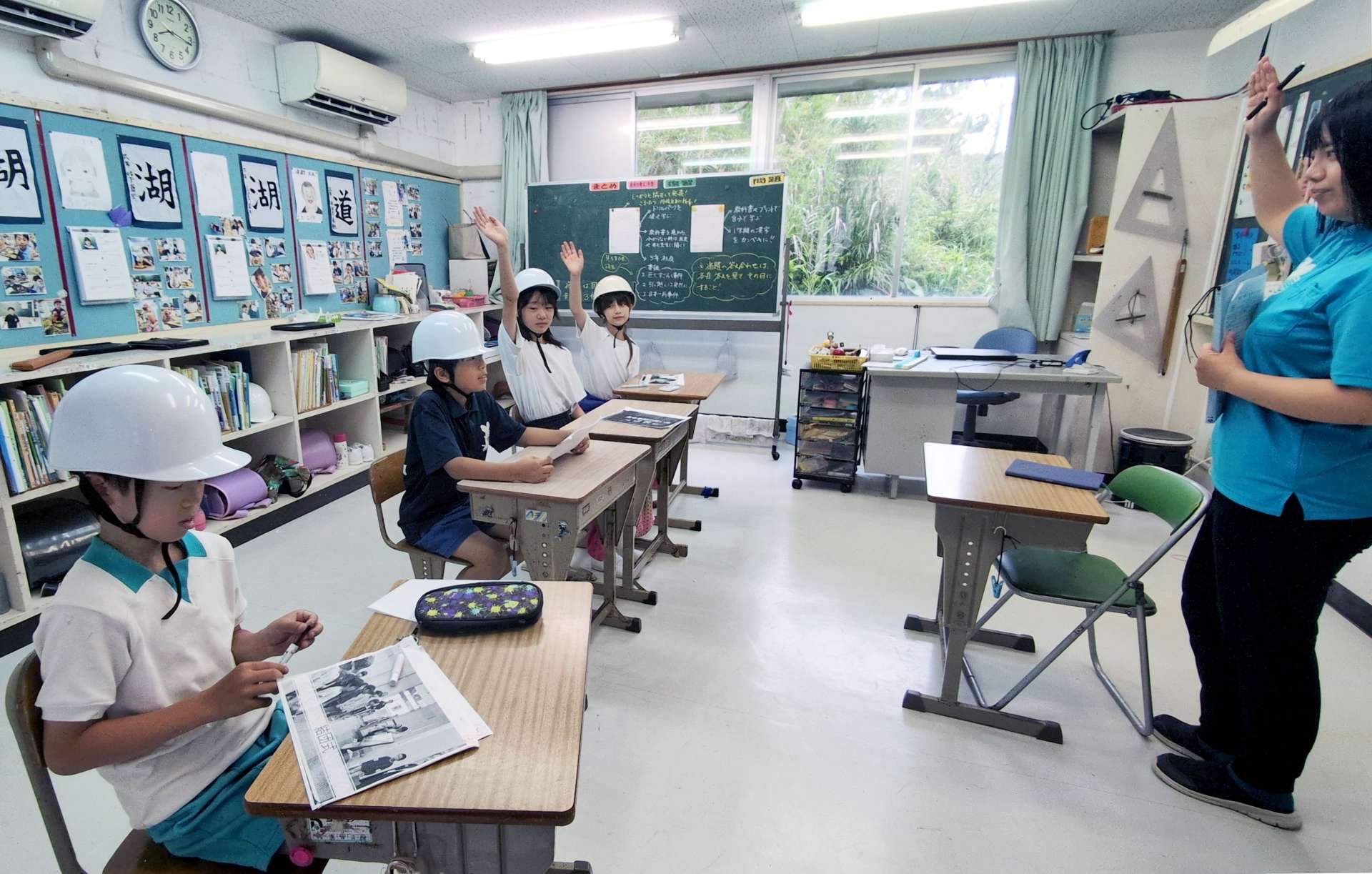 〈関連〉ヘルメットを着けて授業を受ける子どもたち＝２３日午前８時１５分ごろ、十島村悪石島の悪石島学園（同学園提供）