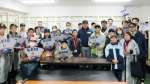 慶応の堀井哲也監督と一緒に記念写真に収まる子供たち＝東京都