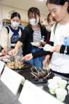 歯の健康に配慮した「歯磨きスイーツ」を手に取る学生＝鹿児島市の鹿児島大学