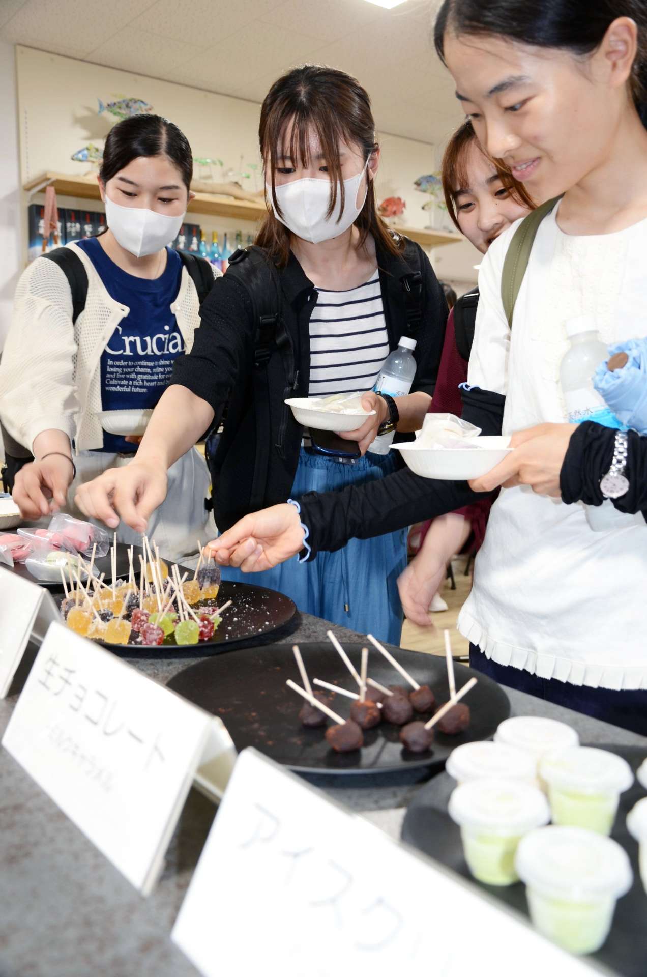歯の健康に配慮した「歯磨きスイーツ」を手に取る学生＝鹿児島市の鹿児島大学