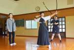 休日に鹿屋中学校の弓道部員を指導する東入来孝子さん＝１５日、鹿屋市弓道場