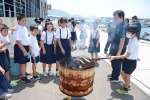 カツオのわら焼きを体験する児童＝枕崎市の枕崎お魚センター