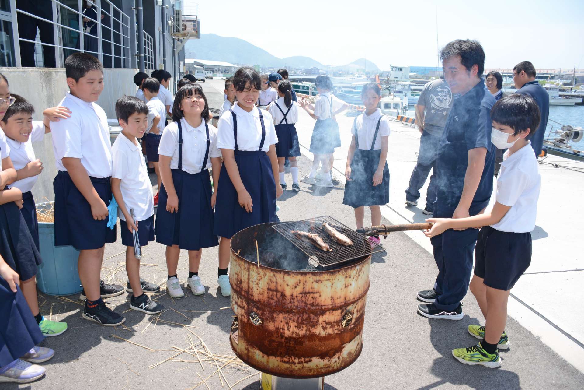 カツオのわら焼きを体験する児童＝枕崎市の枕崎お魚センター