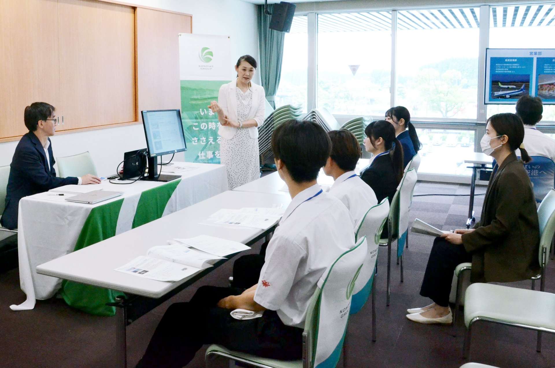 空港業務に携わる企業・団体合同の採用説明会に初めて参加し、来場者に業務内容を説明する鴻池エアーホールディングの担当者＝２１日、霧島市溝辺町麓の鹿児島空港